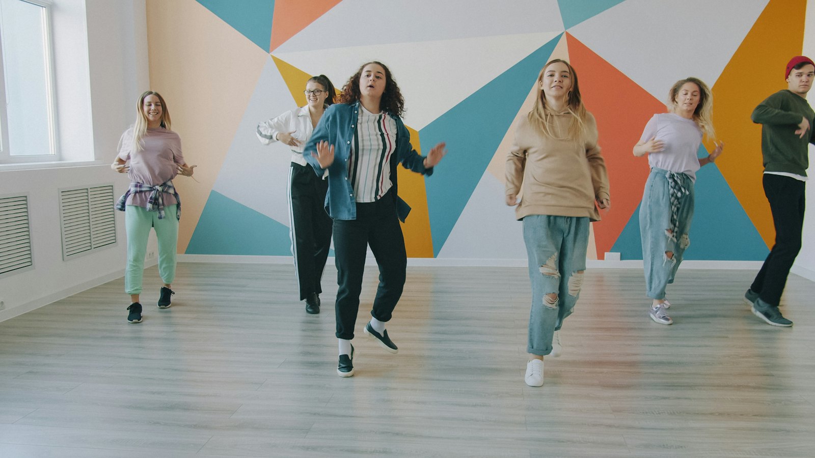 Groupe de danseurs en cours dans un studio coloré
