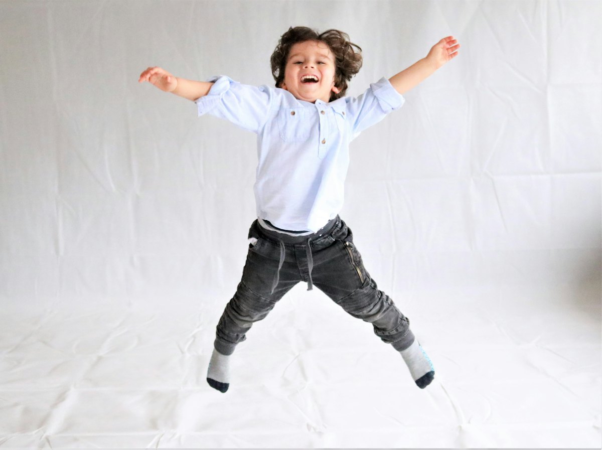 Enfant qui saute de joie, bras écartés