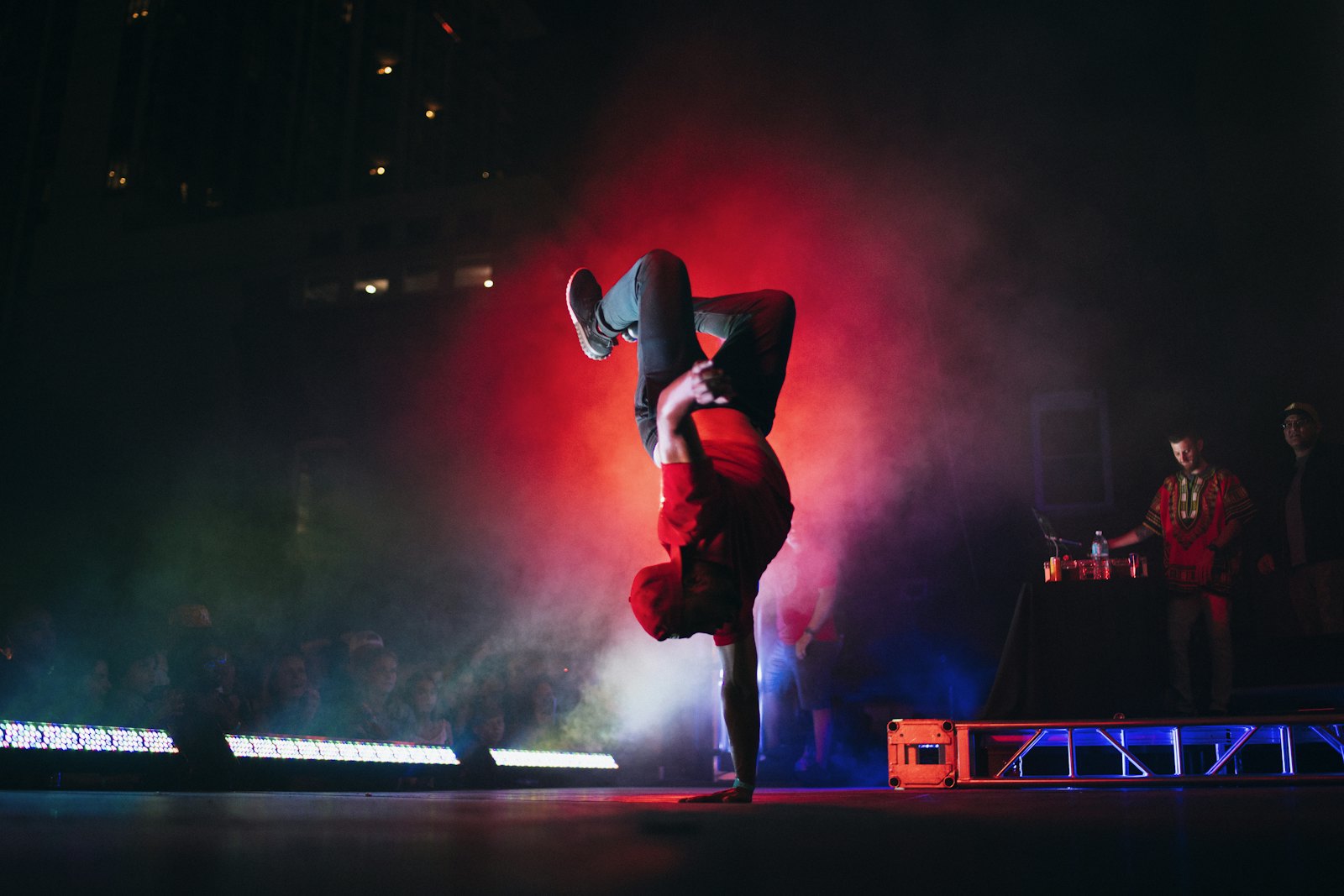 Danseur hip-hop en équilibre sur une main, sous les projecteurs